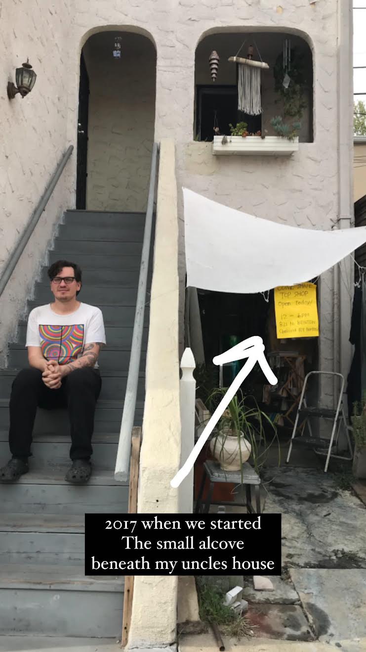 A person sits on a staircase outside a two-level Los Angeles home.