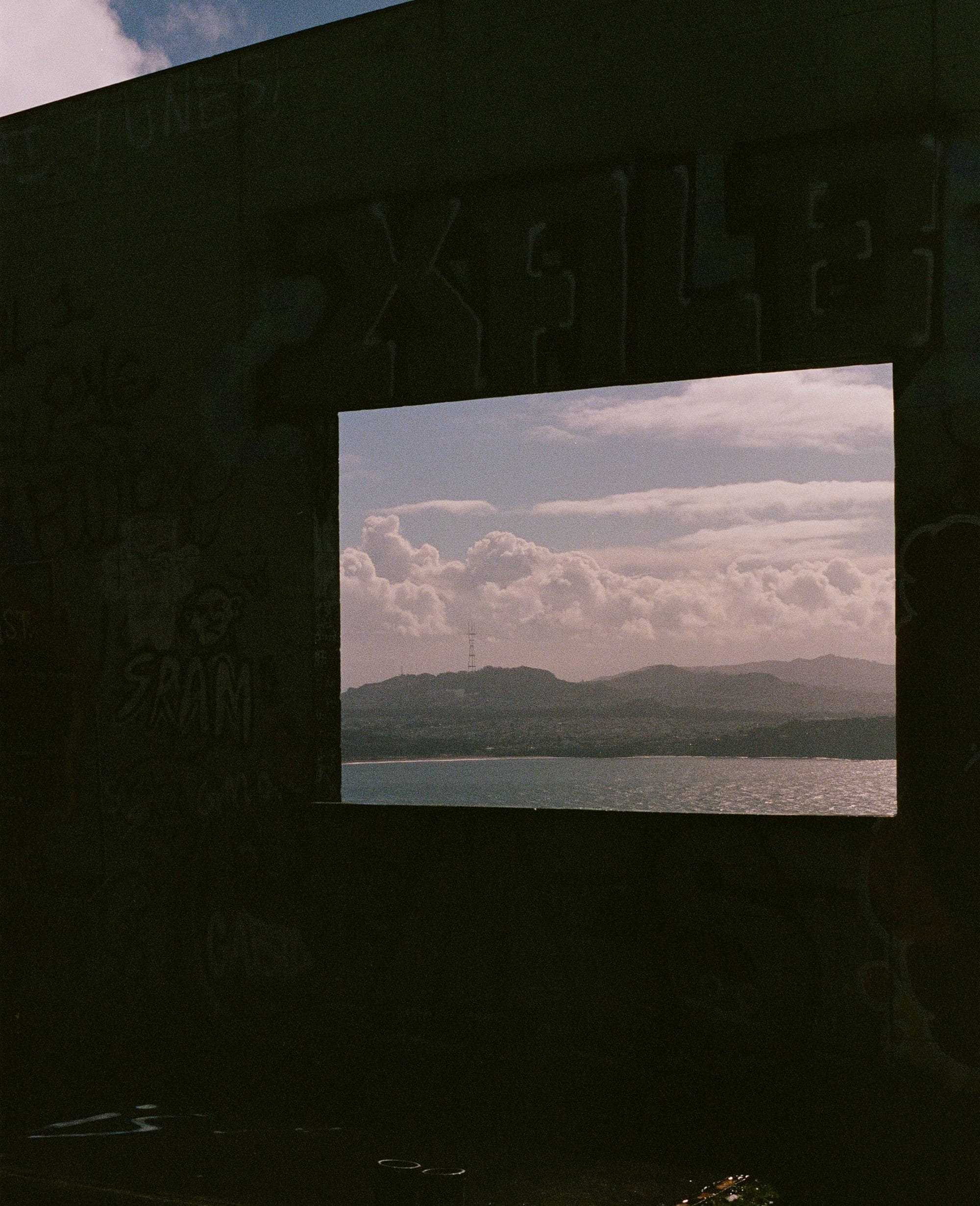 The San Francisco skyline as seen inside a window in a dilapidated building.