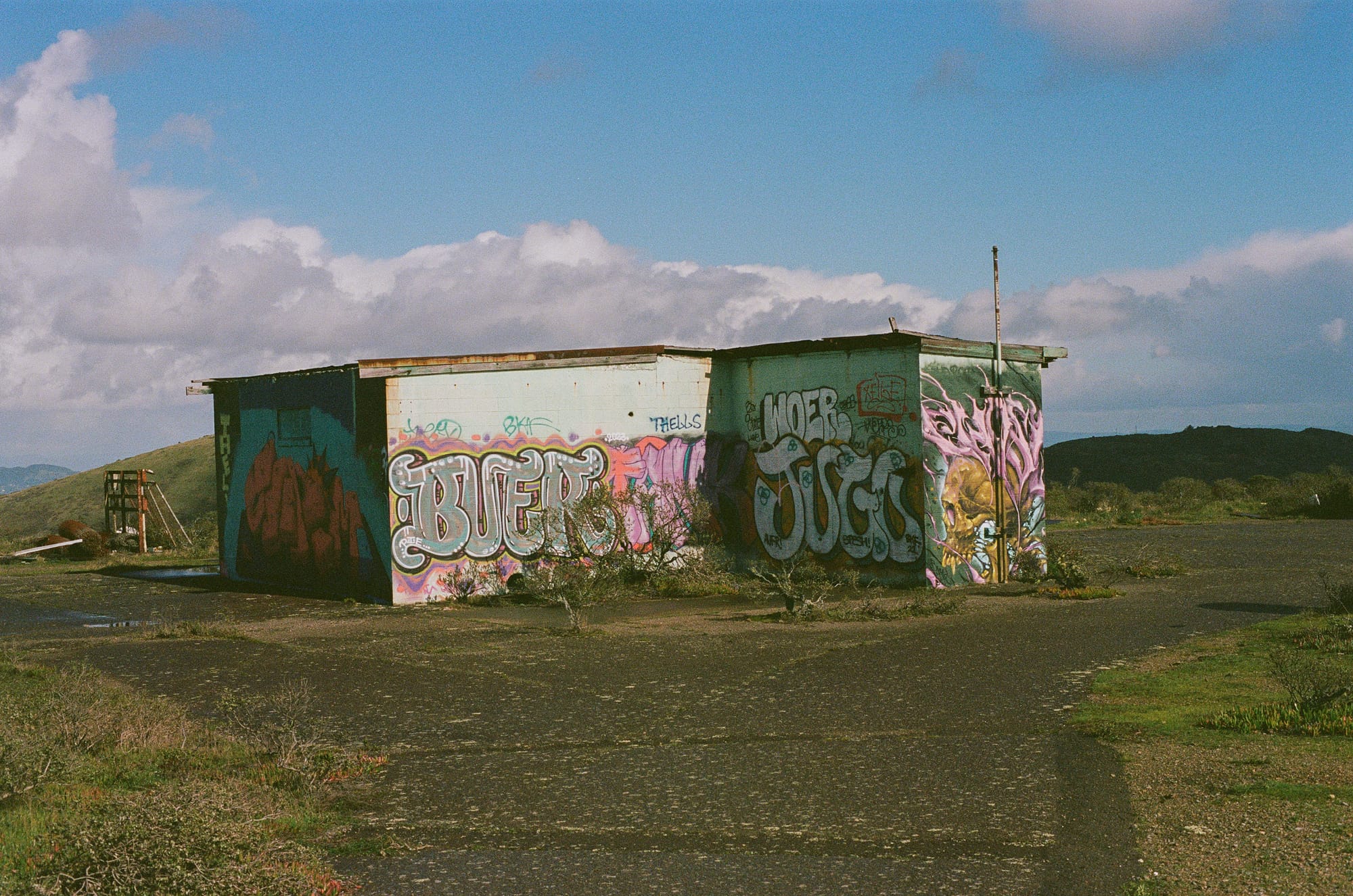 A graffiti-covered structure atop a hill in the Bay Area.